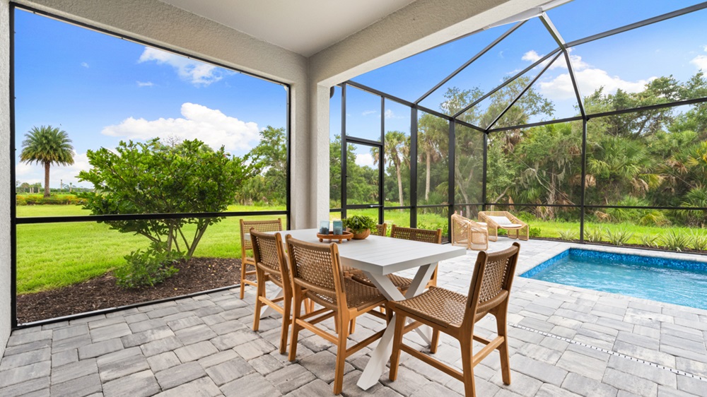 Screened lanai and pool deck of an Anastasia home overlooking green preserve views